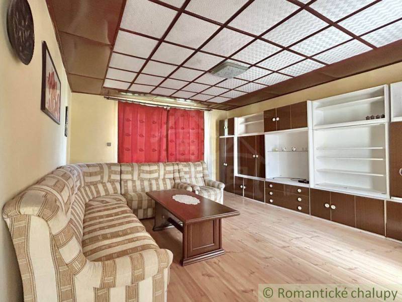 Living room in a family house with a sofa, wooden table, and wall unit.