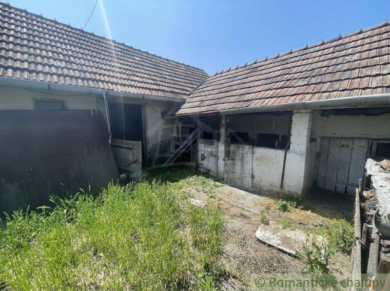 The yard of a family house in Nové Zámky with grass and an old roof.