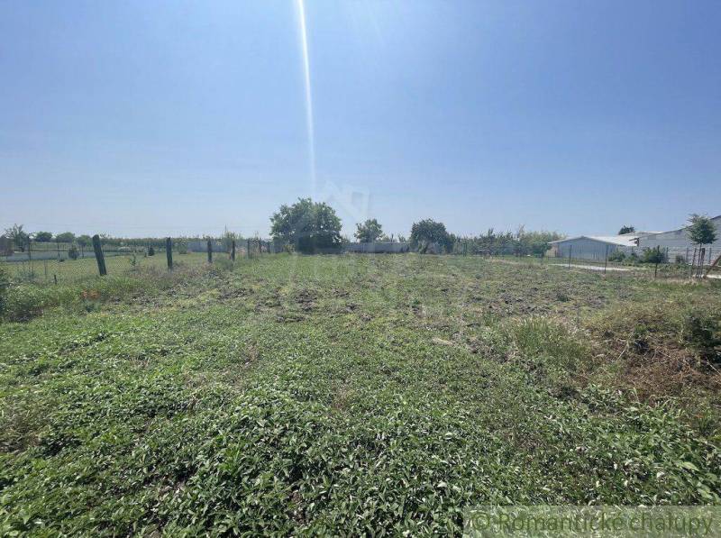 A grassy plot in Nové Zámky, suitable for building a family house, with visible fencing.