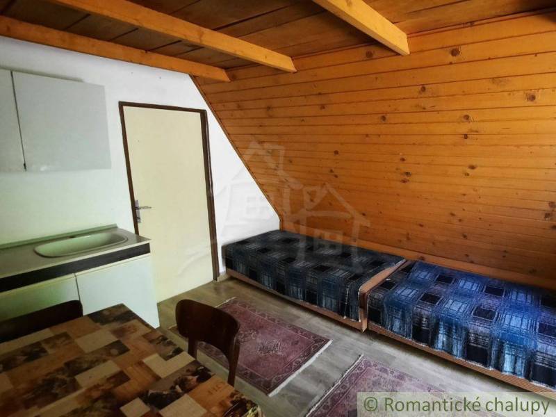 The interior of a cabin with wooden paneling, a sofa, and a dining table.