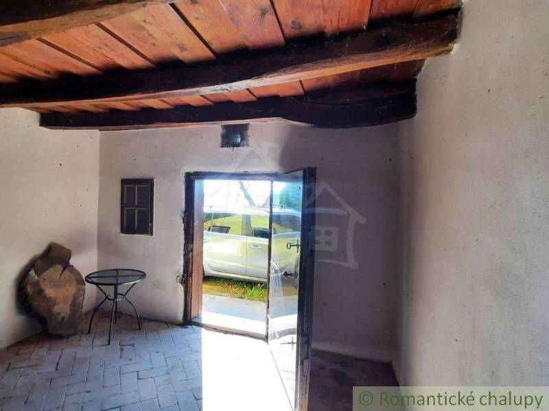 Wooden ceiling and glass doors in the cabin with a view to the exterior.
