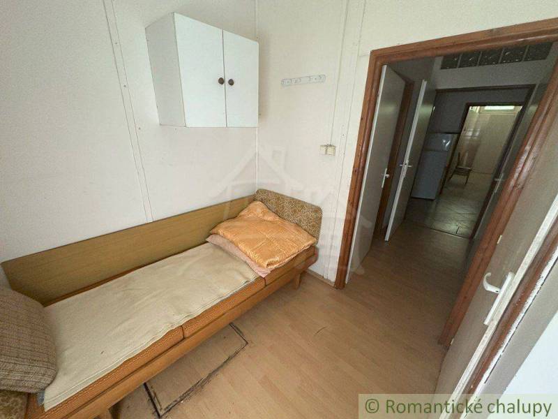 A simple room with a bed and a cabinet in a family house.