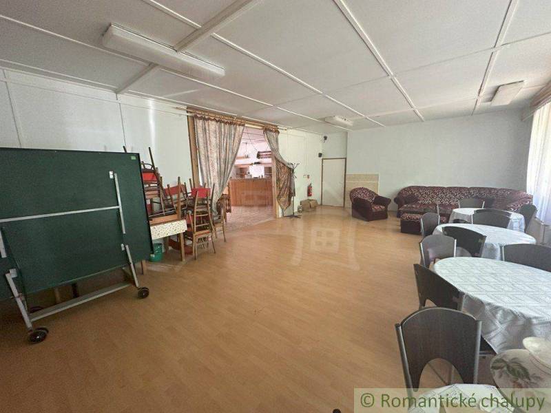 A large room with sofas, tables, chairs, and a curtain in a family house.