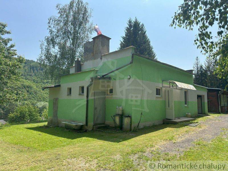 A family house in Poltár with a green facade, surrounded by nature and a peaceful environment.