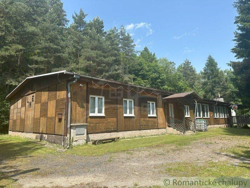 The exterior of a family house surrounded by a forest in Poltár under a blue sky.