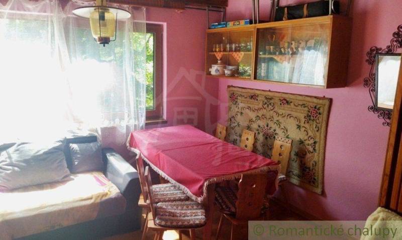 The interior of the cottage with pink walls, a dining table, and a sofa creates a cozy atmosphere.