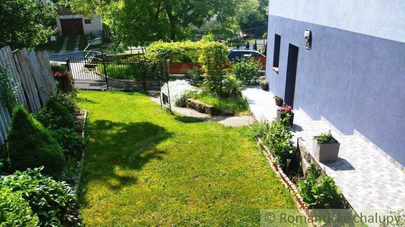 A garden at a family house in Spišská Nová Ves with greenery and a driveway.
