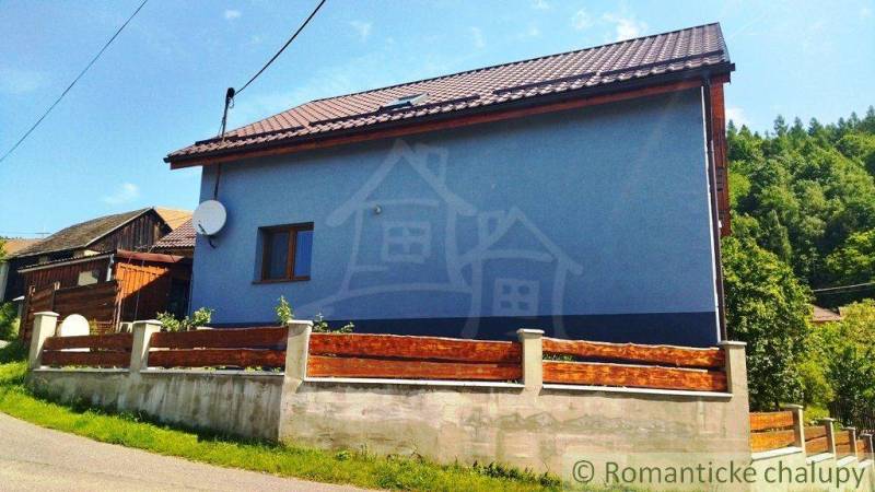 A family house in Spišská Nová Ves with a satellite dish and a wooden fence.