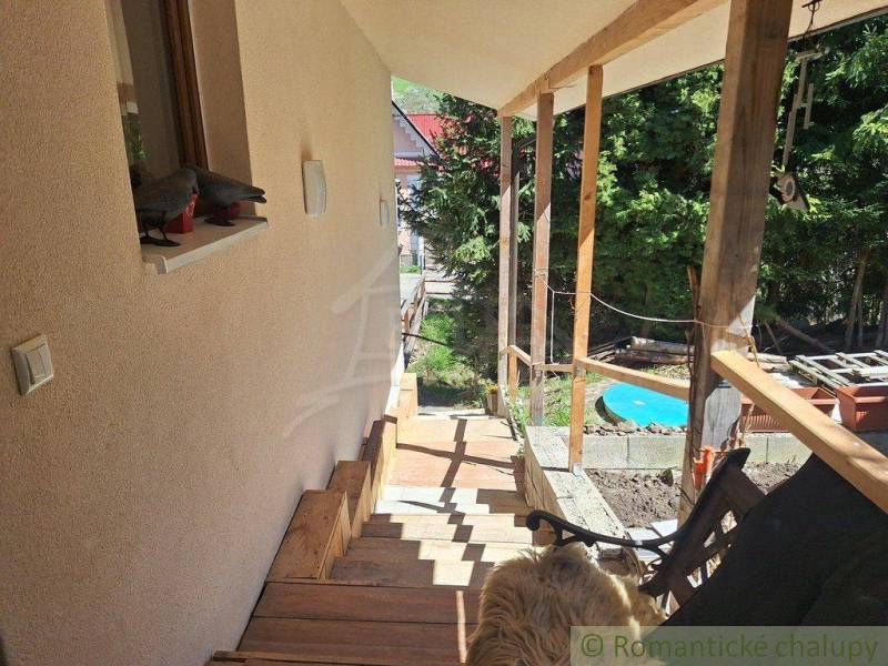 The garden of a family house in Liptovský Mikuláš with wooden stairs, a dog, and a gazebo.