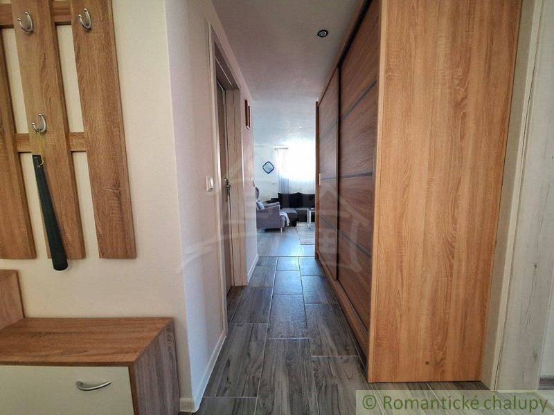 A hallway with wooden furniture and tiles in a family house.