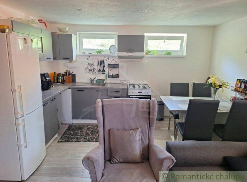 A kitchen in a family house with furniture, a sofa, and a dining table.