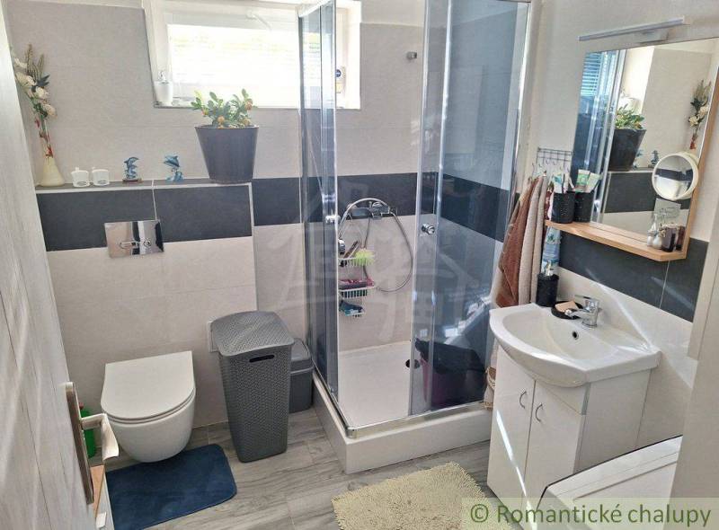A bathroom in a family house with a glass shower enclosure and comfortable amenities.
