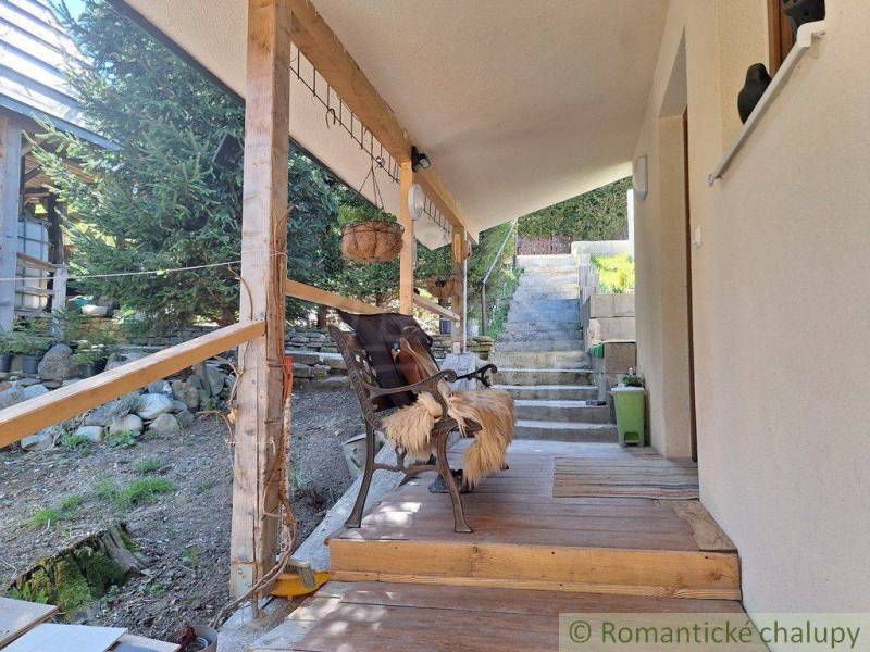 The veranda of a family house in Liptovský Mikuláš with wooden pillars and a metal chair.
