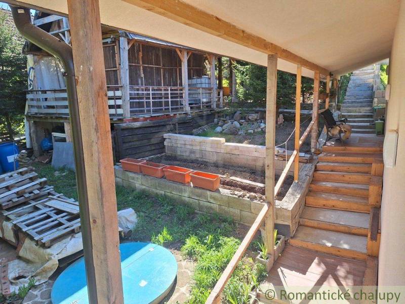 A family house in Liptovský Mikuláš with a terrace, walkway, and wooden structures in the garden.