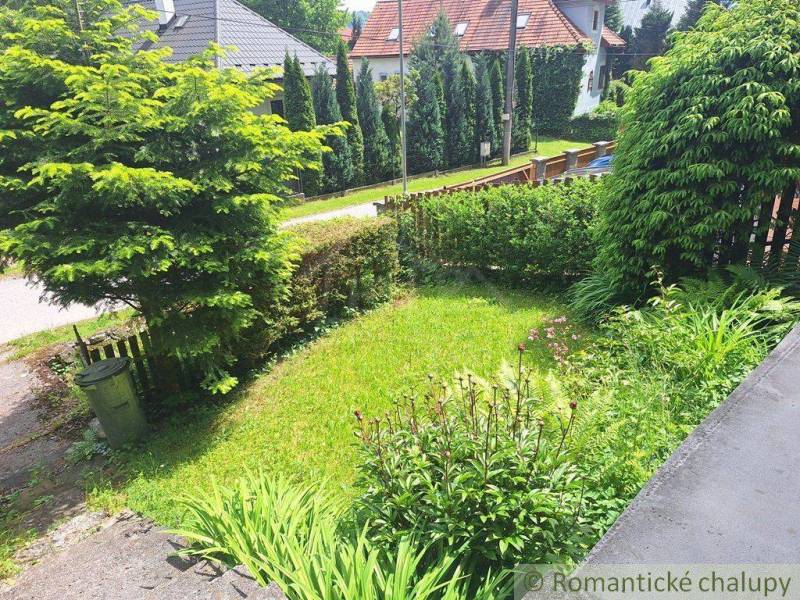 The garden of a family house in Ružomberok with well-maintained grass and shrubs.