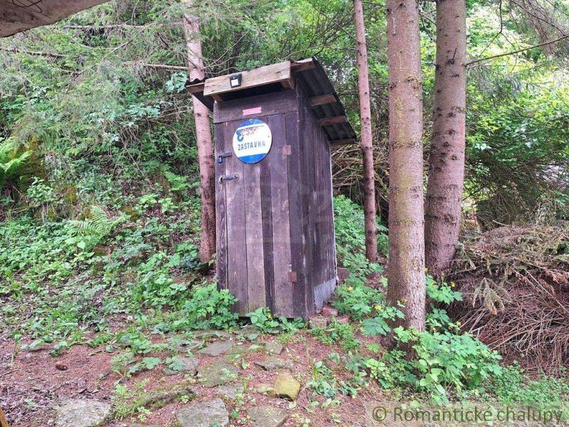 A wooden hut in the middle of the forest near Ružomberok, next to a family house.