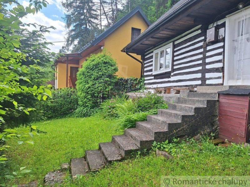 A traditional family house in Ružomberok surrounded by greenery and a lush garden.