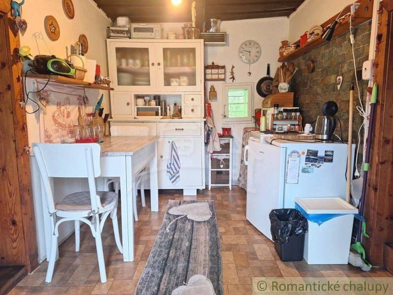 A rustic kitchen in a family house with wooden furniture and decorations on the walls.