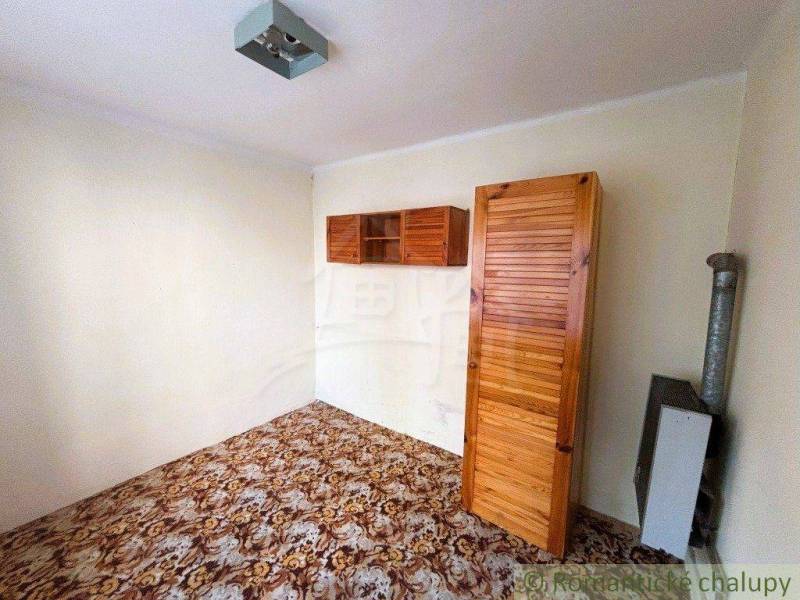 A room in a family house with cabinets, doors, decorated floor, simple furnishings.