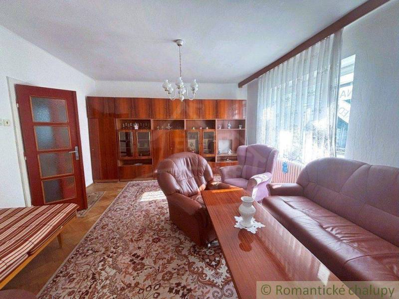 A living room in a family house with brown furniture and pink upholstered seating.