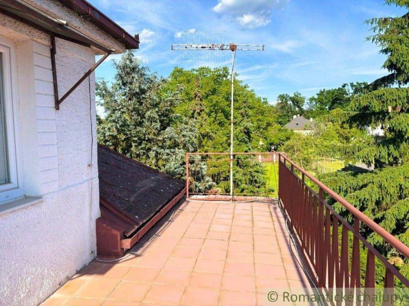 The balcony of a family house in Plavecký Štvrtok with a view of the trees and an antenna.
