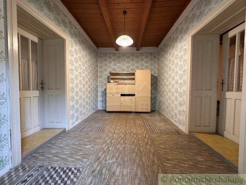 Wooden ceiling paneling and patterned walls in the cabin create a cozy interior.