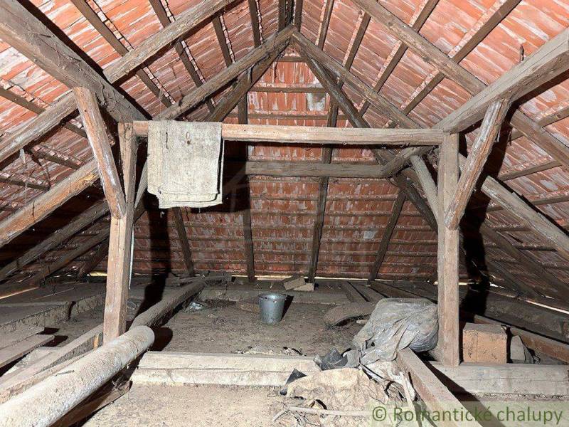 Attic space with old wooden structure and storage items in the cabin.
