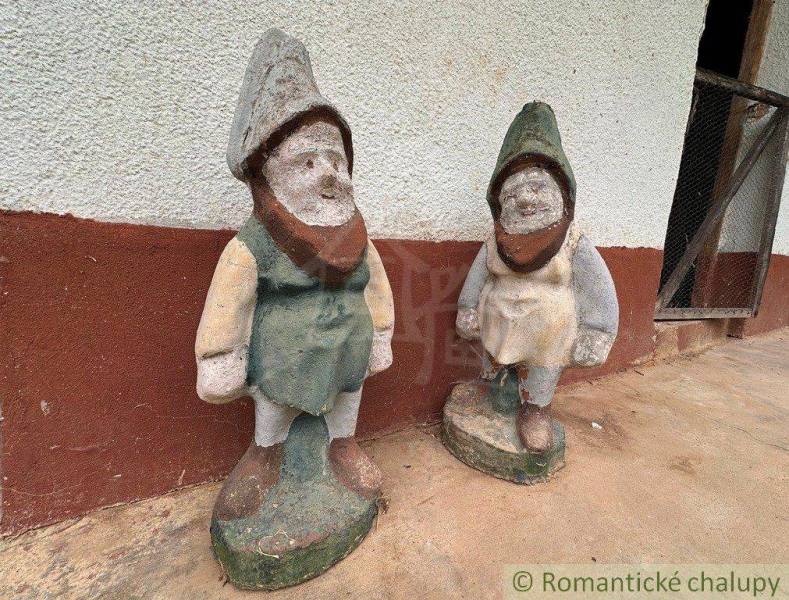 Stone dwarf statues at the cottage in Nové Zámky, on a concrete floor.