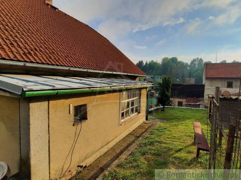 A family house in Žiar nad Hronom with a red roof and a manicured grassy garden.