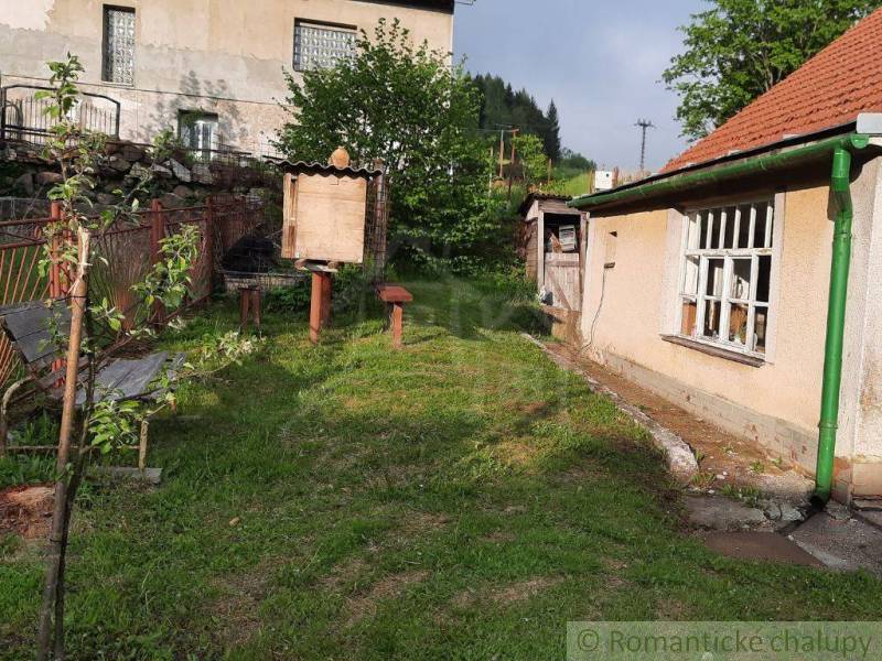 A garden at a family house in Žiar nad Hronom with a wooden bench and a shelter.
