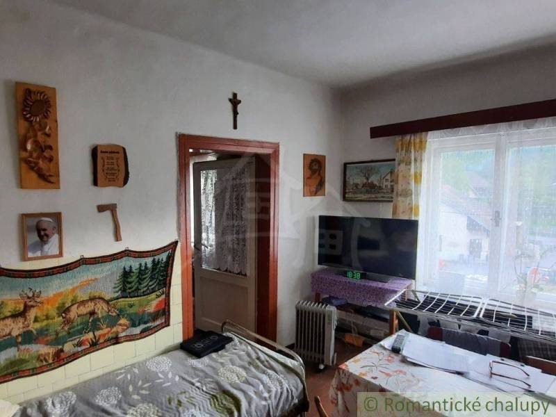 Interior of a family house with wall decorations, a television, and balcony doors.