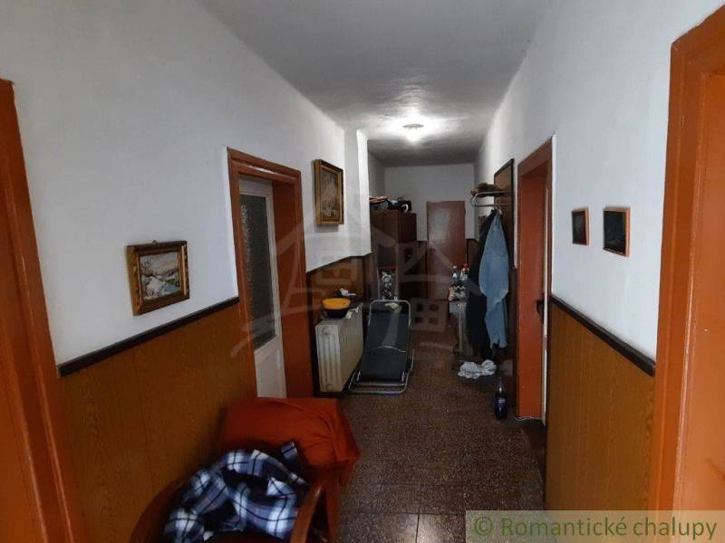Hallway in a family house with furniture, decorations, and clothes on a hanger.