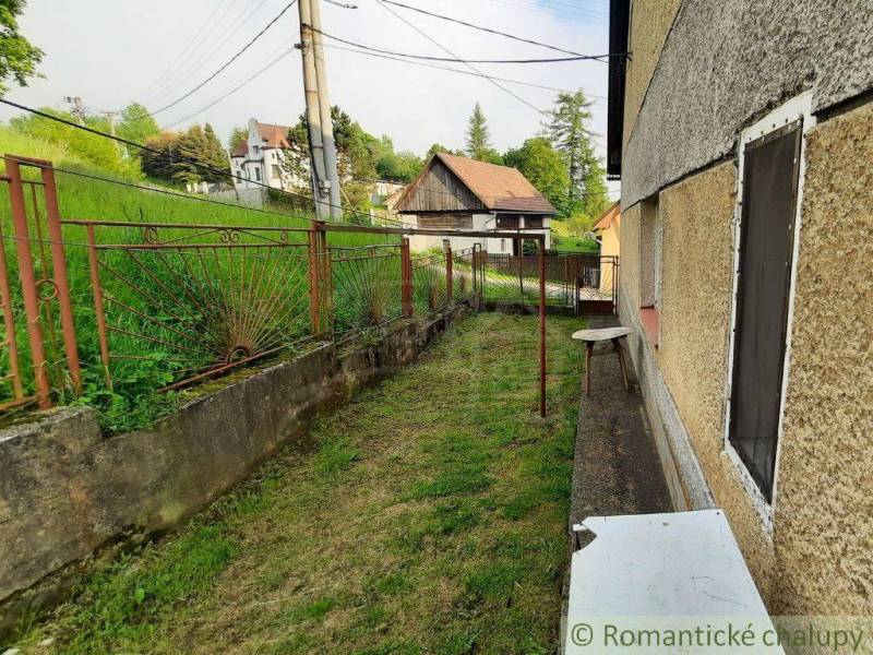 A family house in Žiar nad Hronom with a small yard and a metal fence, view of the houses.