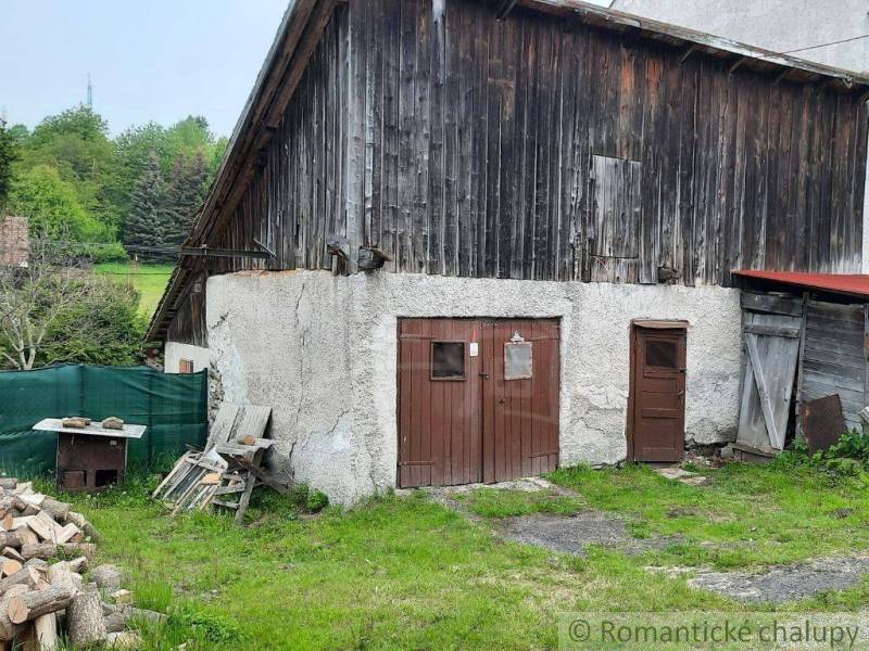 A barn at a family house in Žiar nad Hronom, surrounded by greenery and wood.