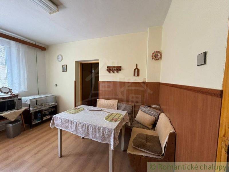 Dining area in a family house with a bench, table, and microwave.