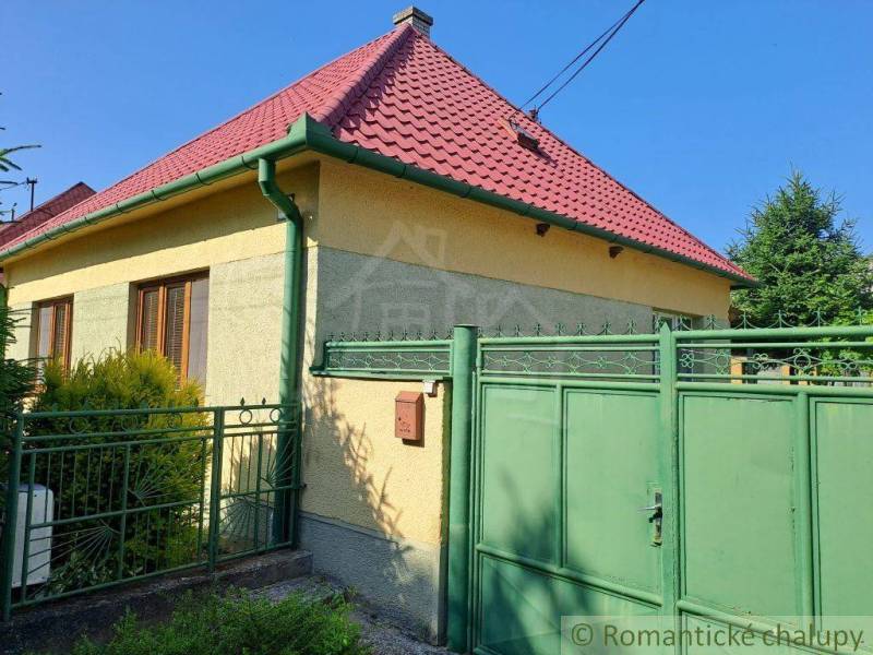 A family house in Dvorníky with a red roof and a green gate.