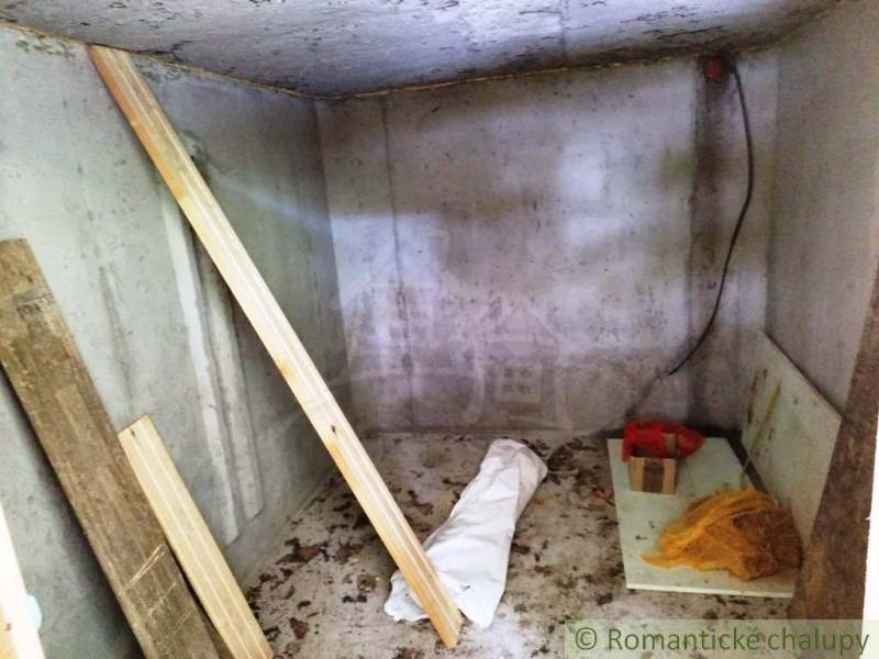 A cellar in a cottage with wood and building materials.