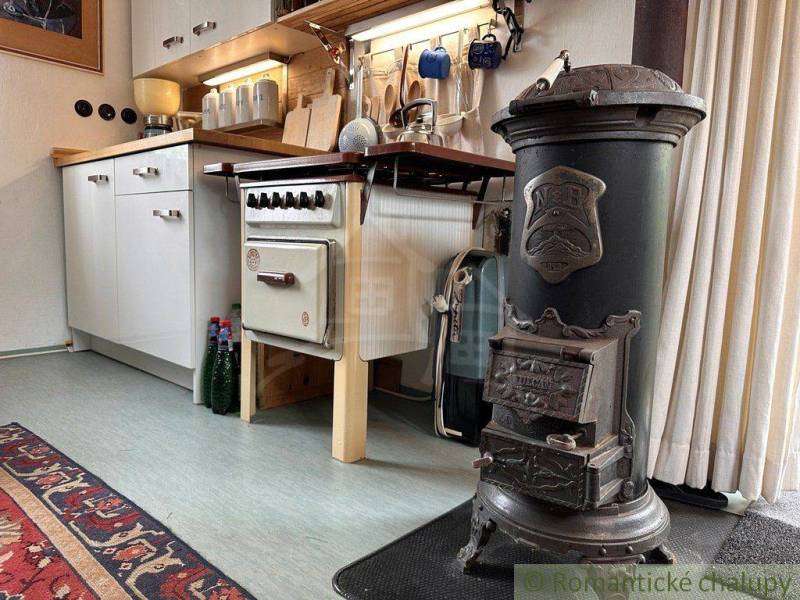 Kitchen in a cottage with an old stove and rustic elements.