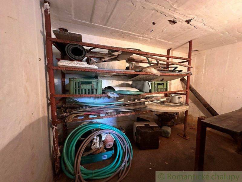A shelf in the cottage with various tools and garden hoses.