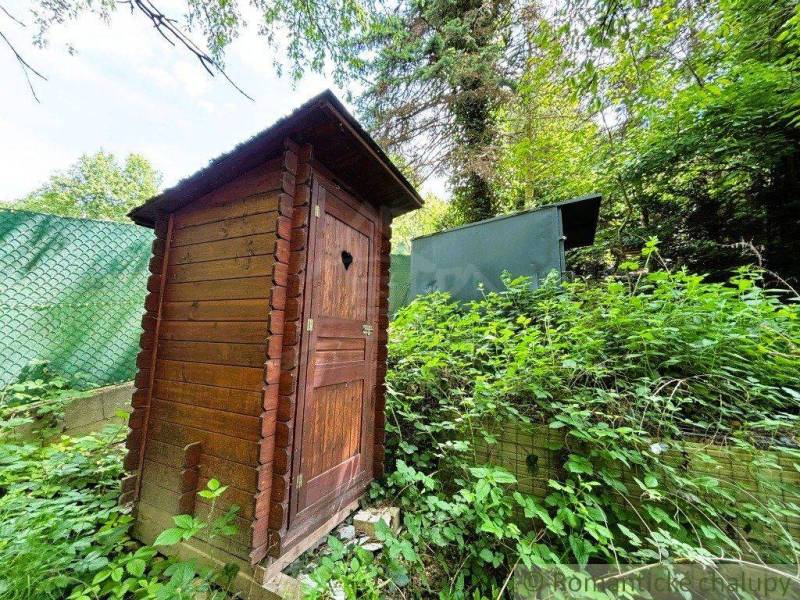 A wooden latrine in a natural setting near a cabin in Bratislava - Lamač.