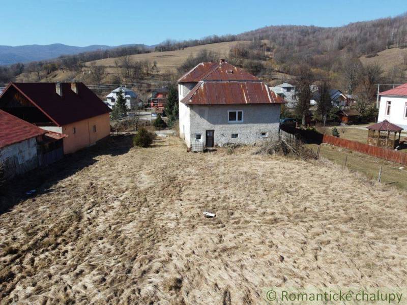A family house in Nová Sedlica with a garden and hilly landscape in the background.