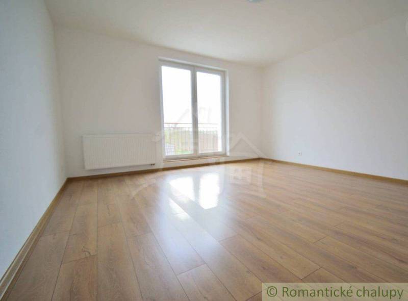 An empty room with a wooden floor and a large window in a family house.
