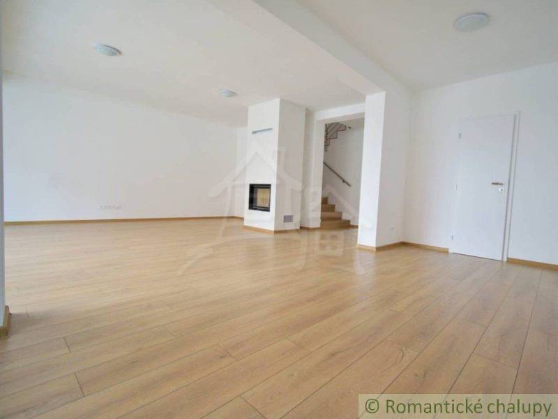 Spacious living area with wooden flooring and a fireplace in a family house.
