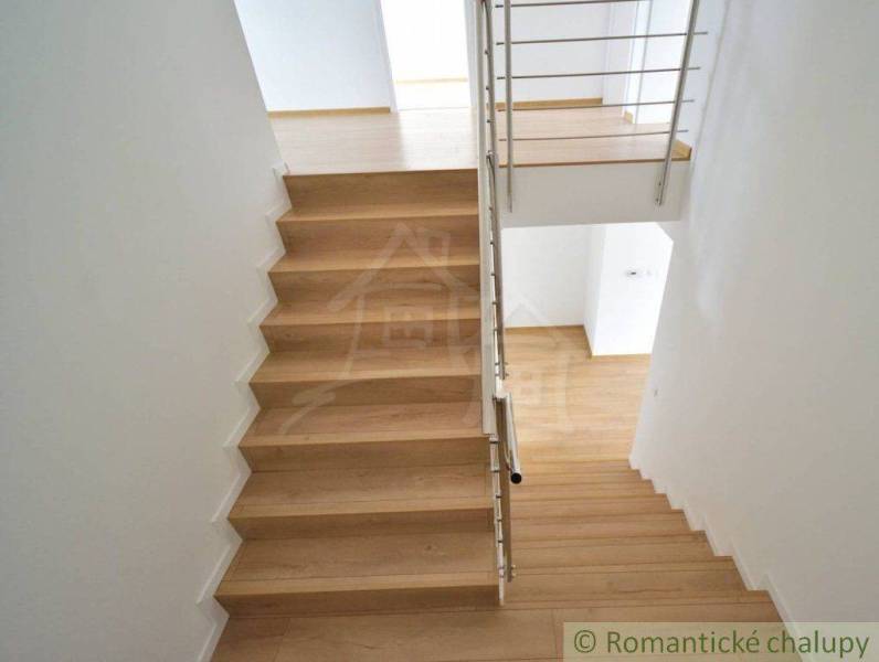 A staircase with wooden steps and a metal railing in a family house.