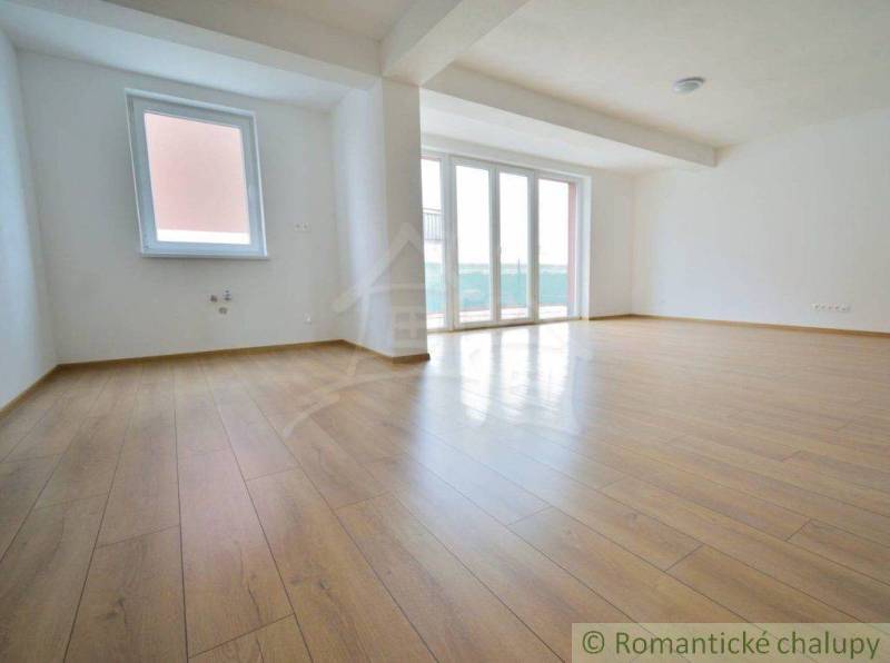 A spacious living room in a family house with wooden flooring and large windows.
