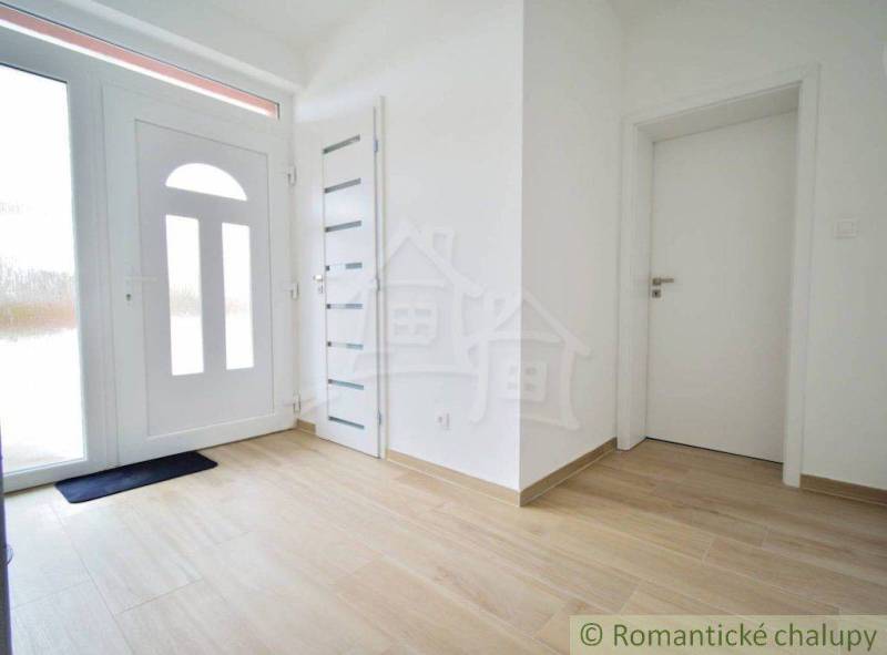 Entrance hall in a family house with wooden flooring and white doors.
