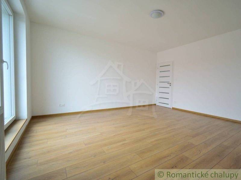 Spacious room with wooden floor and large window in a family house.