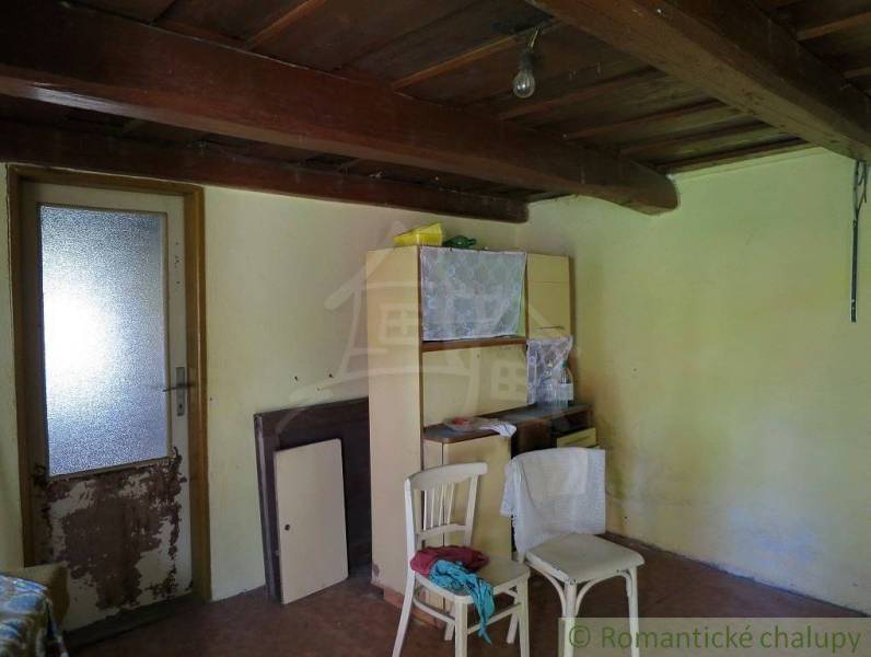 The interior of a family house with a wooden ceiling and basic furniture creates a retro atmosphere.