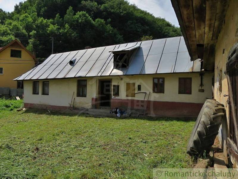 A family house in Hačava surrounded by greenery, with a gable roof, and a mowed lawn in front of it.