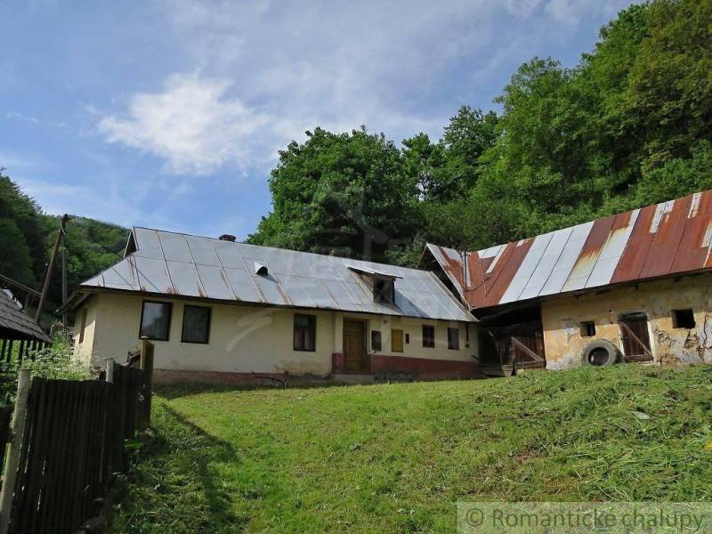 A family house in Hačava with a metal roof surrounded by nature and greenery.